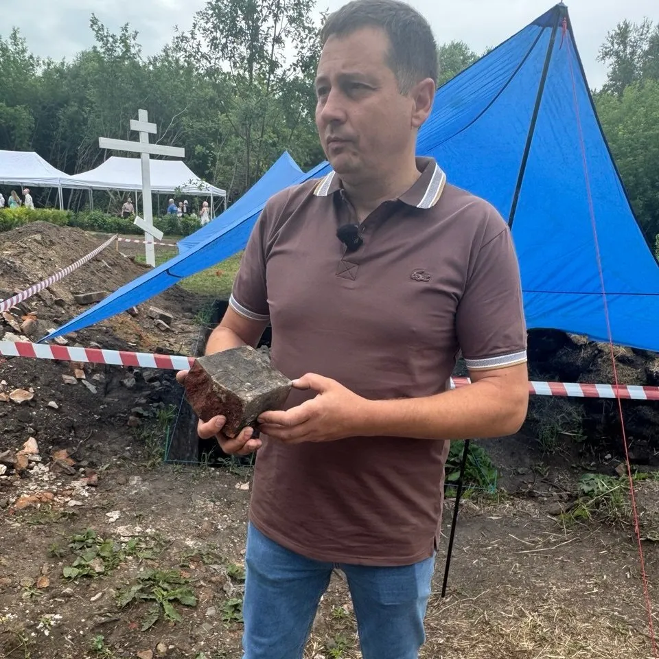 Археолог Евгений Барсуков Археолог держит кирпич с клеймом
